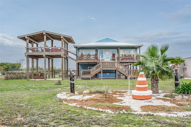 back of house with a wooden deck and a lawn