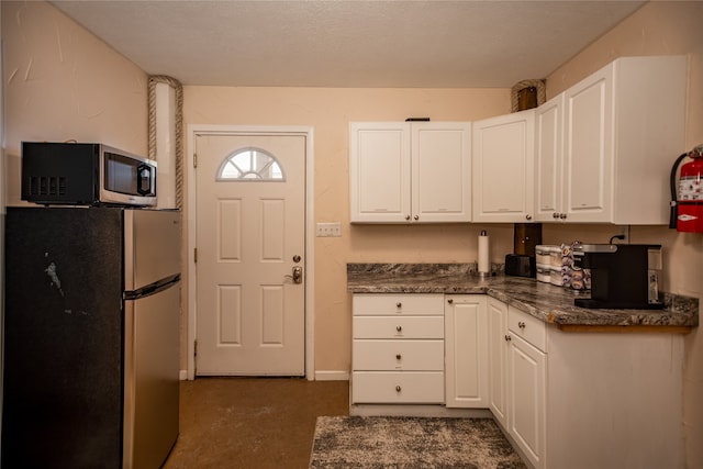 kitchen with white cabinetry, a textured ceiling, and appliances with stainless steel finishes