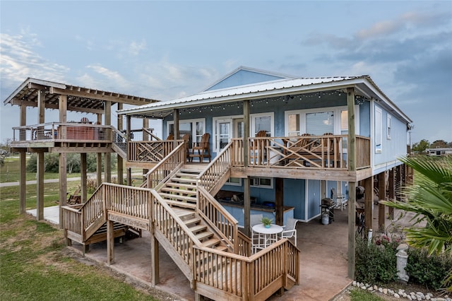 back of house featuring a wooden deck and a patio