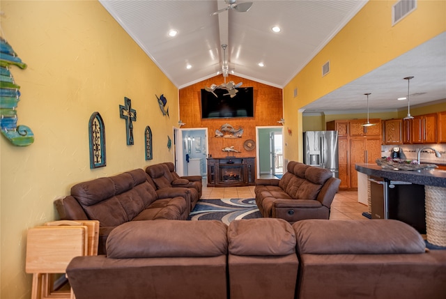 living room with ornamental molding, lofted ceiling, light tile patterned flooring, and ceiling fan