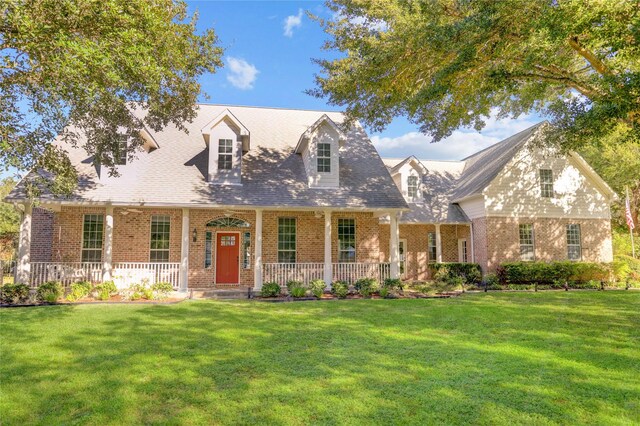 cape cod house featuring a front lawn and a porch