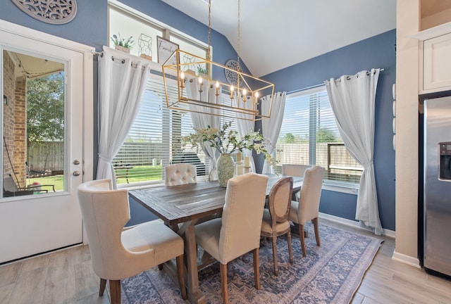 dining area featuring light wood-type flooring, a wealth of natural light, and an inviting chandelier