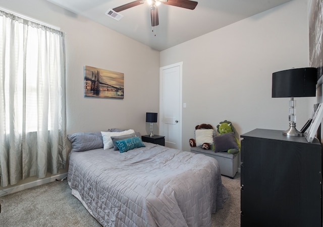 bedroom with light carpet, multiple windows, and ceiling fan