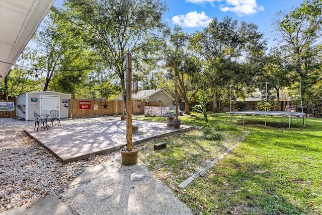 view of yard with a trampoline, a storage unit, and a patio area