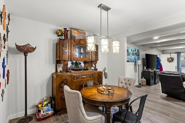 dining space with beamed ceiling and light wood-type flooring