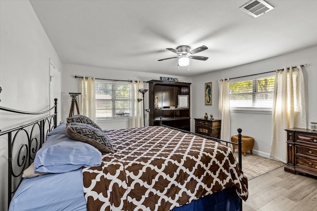 bedroom with multiple windows, ceiling fan, and light hardwood / wood-style flooring