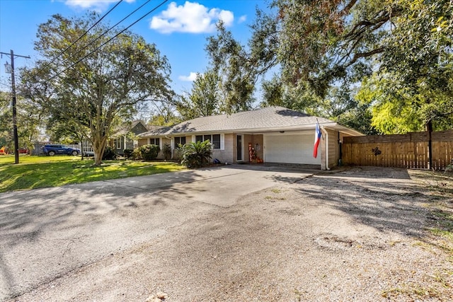 ranch-style home featuring a garage and a front lawn