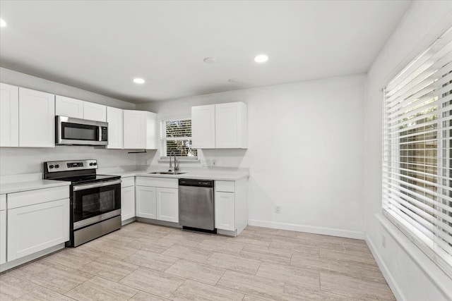 kitchen with sink, white cabinets, and appliances with stainless steel finishes