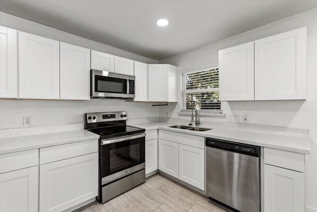 kitchen featuring white cabinetry, sink, and appliances with stainless steel finishes