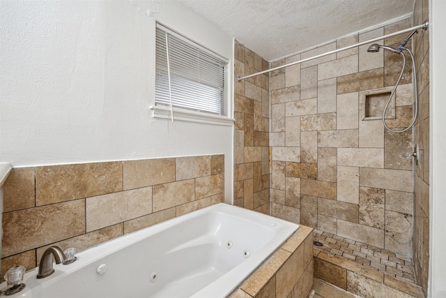 bathroom featuring shower with separate bathtub and a textured ceiling