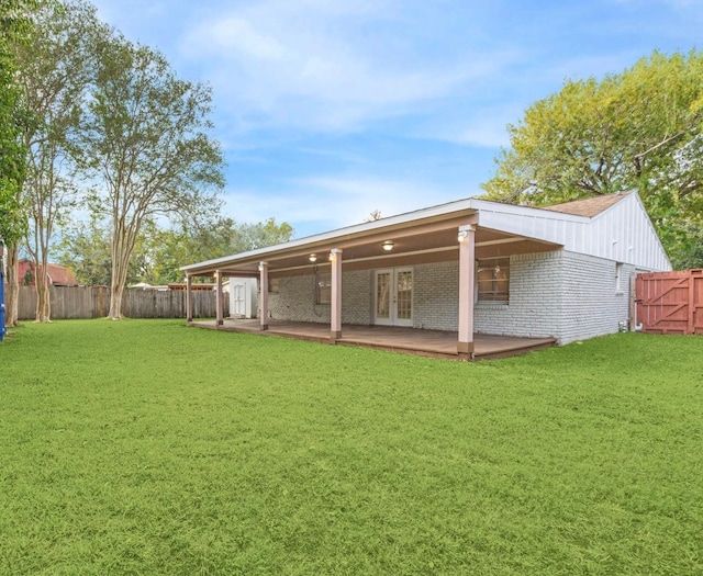 rear view of property with a deck and a lawn