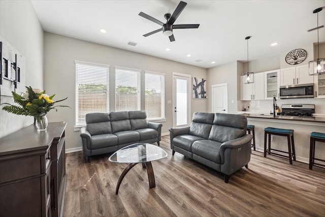 living room with dark hardwood / wood-style flooring and ceiling fan