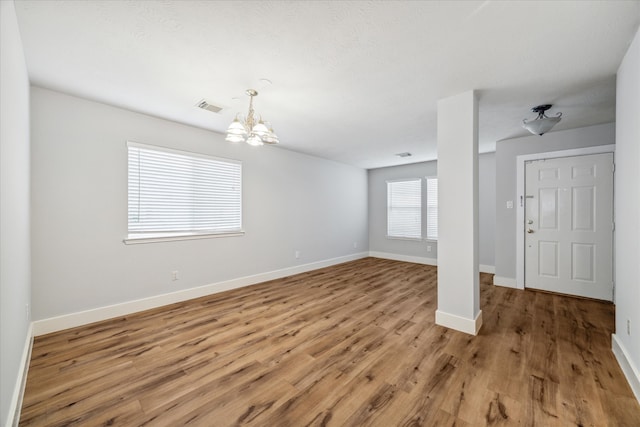 interior space featuring wood-type flooring and a notable chandelier