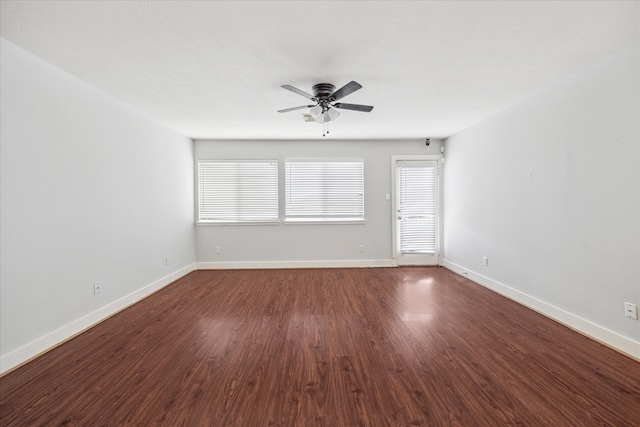 unfurnished room featuring dark wood-type flooring and ceiling fan