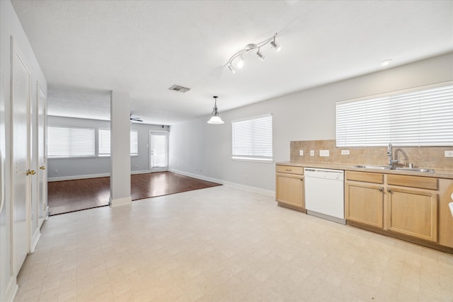 kitchen featuring sink, white dishwasher, ceiling fan, backsplash, and hanging light fixtures