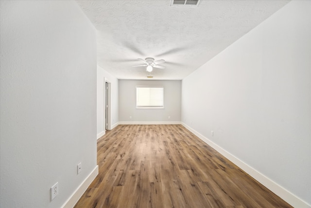 unfurnished room with hardwood / wood-style flooring, ceiling fan, and a textured ceiling