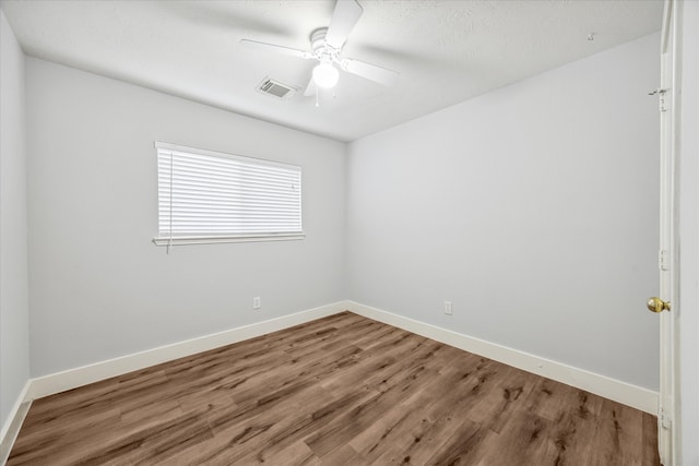 empty room featuring wood-type flooring, ceiling fan, and a textured ceiling