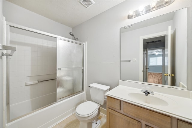 full bathroom featuring shower / bath combination with glass door, a textured ceiling, toilet, and vanity