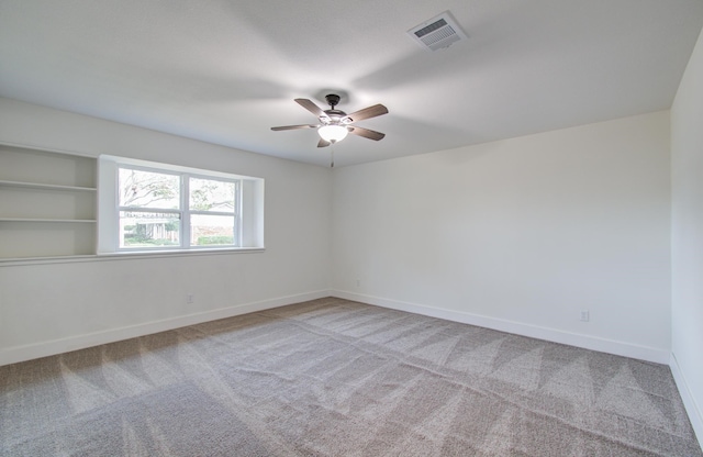 carpeted spare room featuring ceiling fan