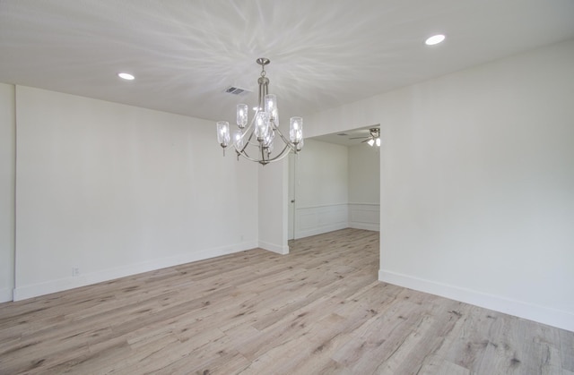 unfurnished dining area with ceiling fan with notable chandelier and light hardwood / wood-style floors