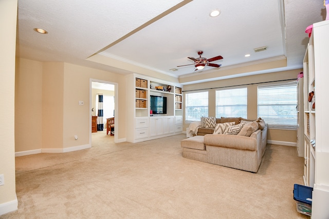 living room featuring a textured ceiling, ornamental molding, light carpet, and a tray ceiling