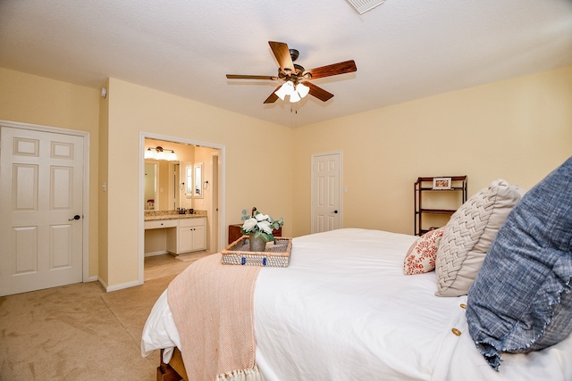 carpeted bedroom with ceiling fan, a textured ceiling, and connected bathroom