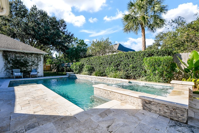 view of pool featuring pool water feature, a patio area, and a hot tub