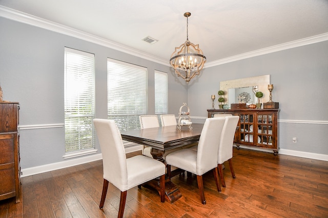 dining area featuring dark hardwood / wood-style flooring, crown molding, and an inviting chandelier