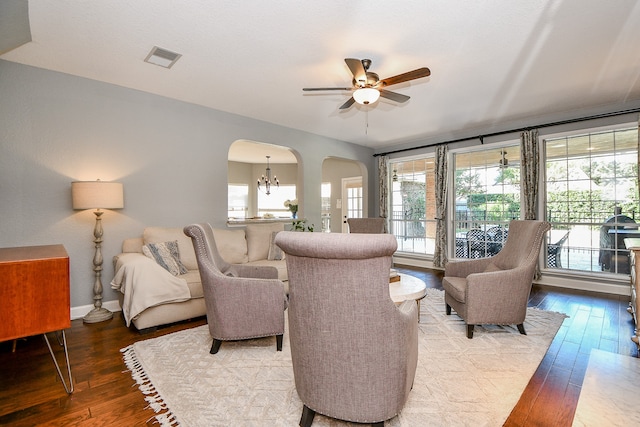 living room featuring hardwood / wood-style floors and ceiling fan with notable chandelier