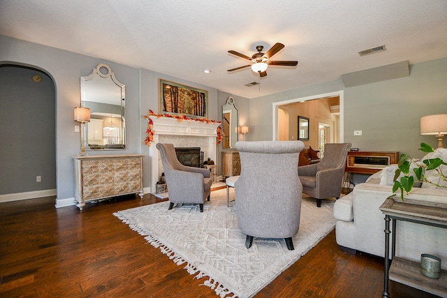 living room featuring dark hardwood / wood-style floors, ceiling fan, a textured ceiling, and a high end fireplace