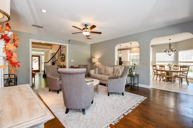 living room with hardwood / wood-style floors and ceiling fan with notable chandelier