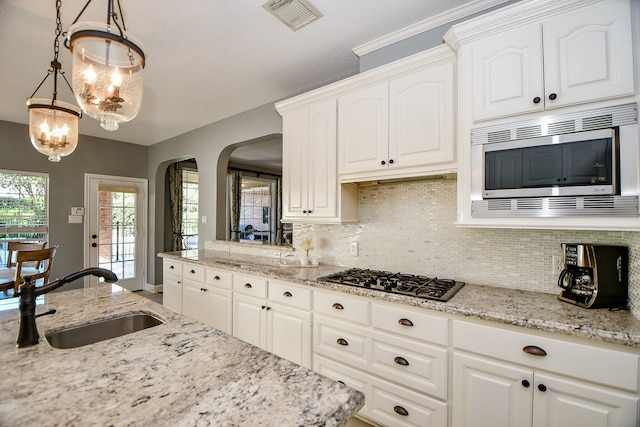 kitchen featuring white cabinets, hanging light fixtures, sink, and appliances with stainless steel finishes