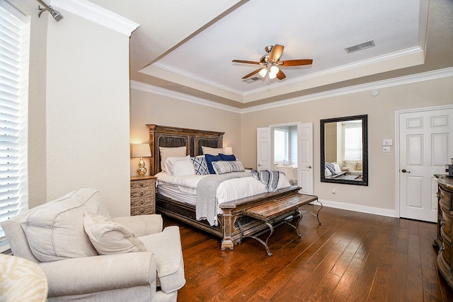 bedroom featuring a tray ceiling, ceiling fan, dark hardwood / wood-style flooring, and crown molding