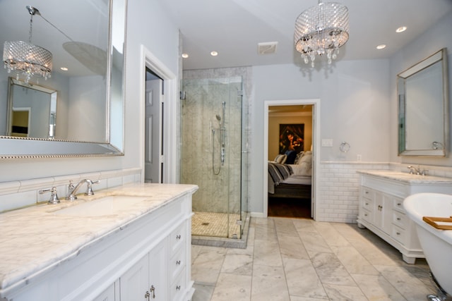 bathroom featuring plus walk in shower, vanity, and an inviting chandelier