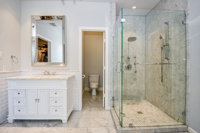 bathroom with a shower with door, vanity, and toilet