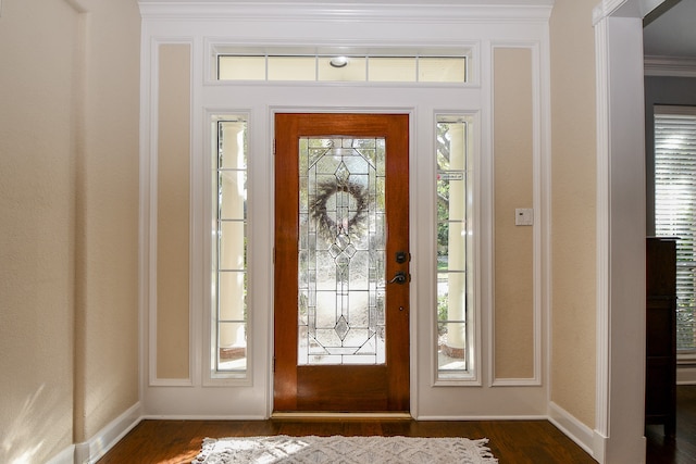 foyer entrance with crown molding, a healthy amount of sunlight, and dark hardwood / wood-style floors