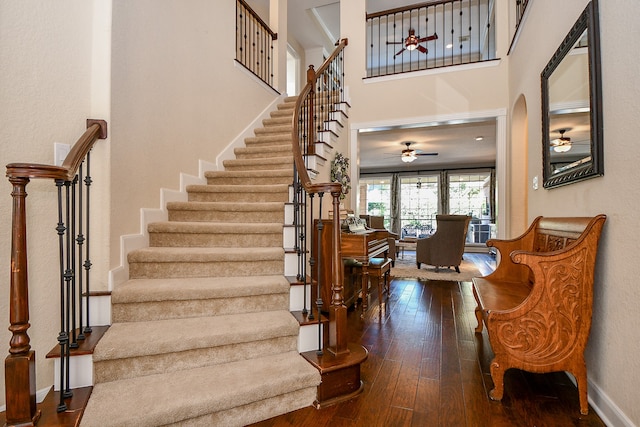 stairs featuring hardwood / wood-style flooring and ceiling fan