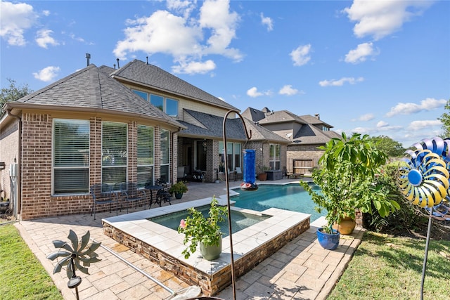 view of swimming pool featuring an in ground hot tub and a patio