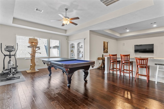 rec room featuring dark wood-type flooring, pool table, and a tray ceiling