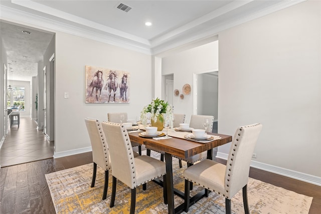 dining area with dark hardwood / wood-style flooring and crown molding