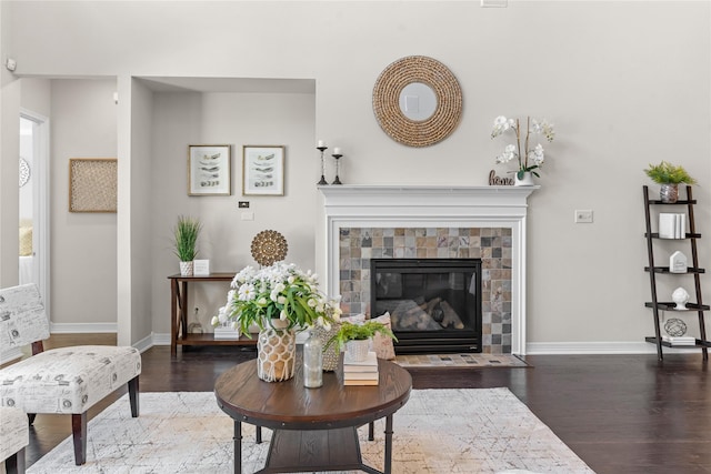 living room with a tiled fireplace and dark hardwood / wood-style floors