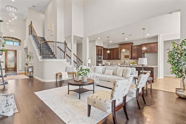 living room featuring dark hardwood / wood-style flooring, a high ceiling, and an inviting chandelier