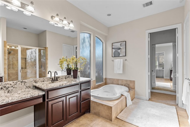 bathroom featuring tile patterned flooring, vanity, and shower with separate bathtub