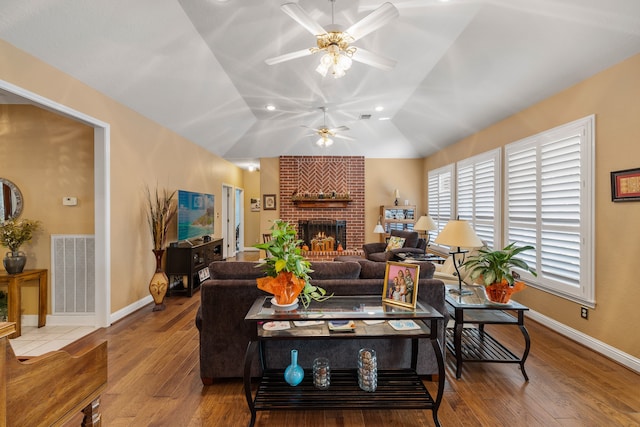 living room with a brick fireplace, hardwood / wood-style floors, lofted ceiling, and ceiling fan