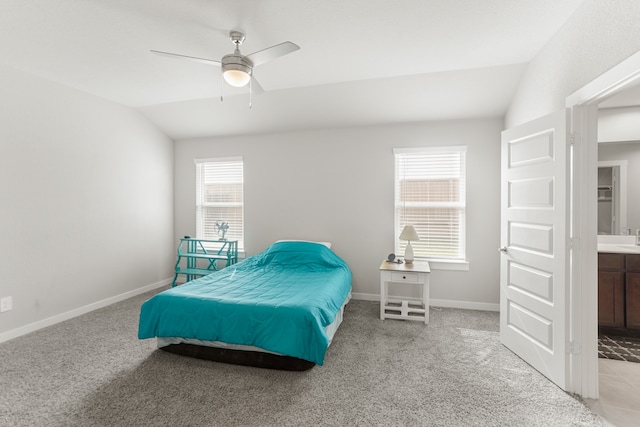 carpeted bedroom with multiple windows, ceiling fan, vaulted ceiling, and connected bathroom