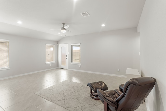 sitting room featuring lofted ceiling, light tile patterned floors, and ceiling fan