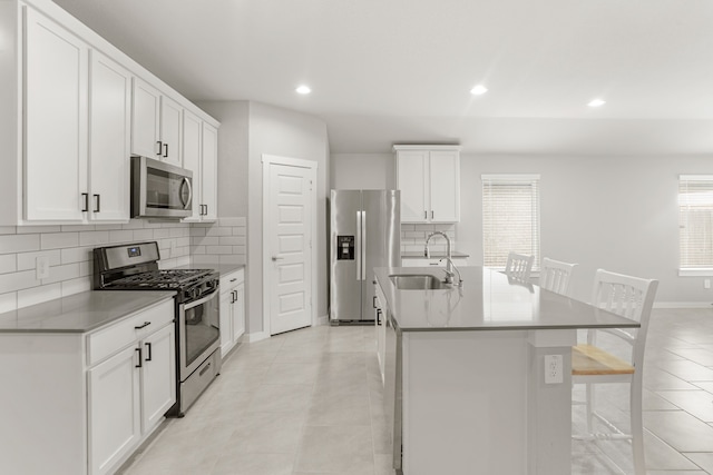 kitchen featuring white cabinetry, appliances with stainless steel finishes, sink, and a kitchen island with sink