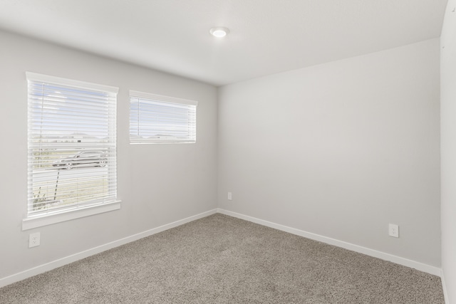 carpeted spare room featuring plenty of natural light