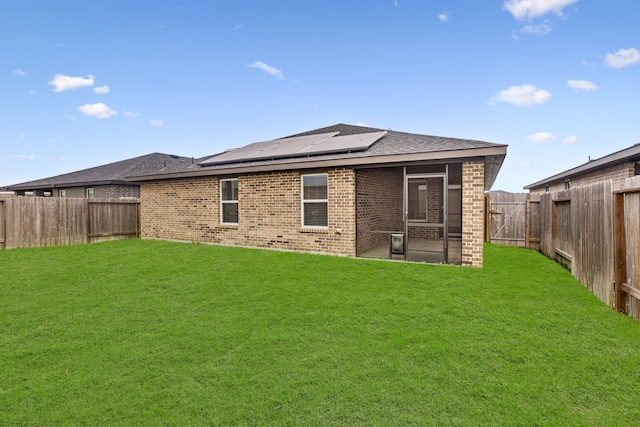 rear view of house featuring solar panels, a patio, and a yard