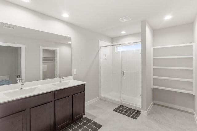 bathroom with tile patterned flooring, vanity, and a shower with door